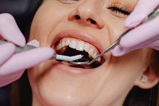 A patient undergoing a dental check-up with dental tools