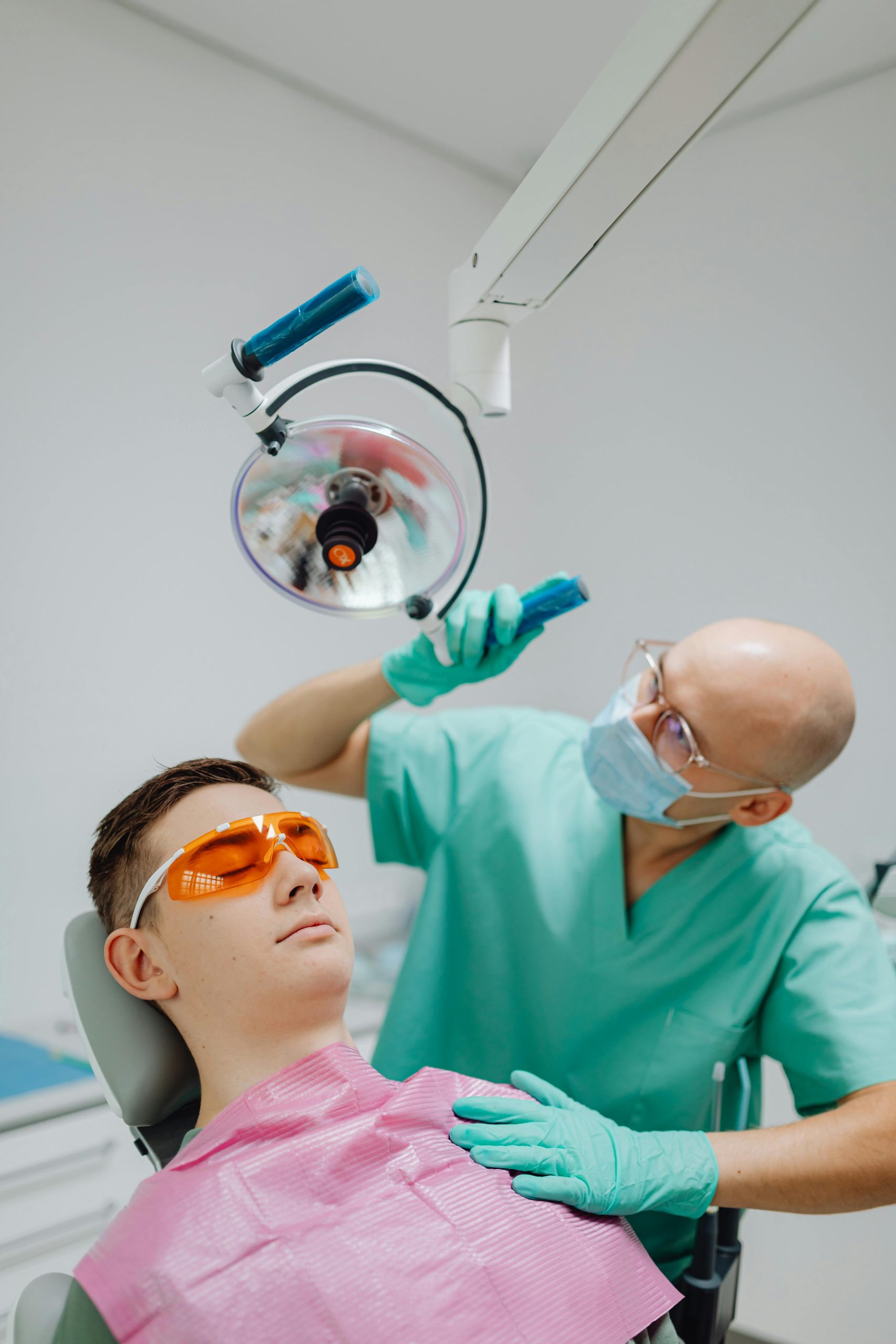 Dentist using a curing light on a patient during a dental procedure