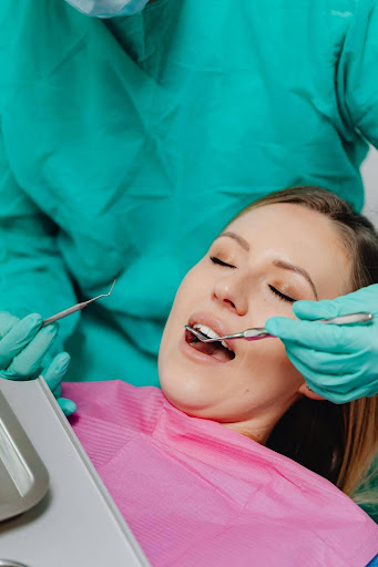 Dentist performing a routine dental exam on a female patient
