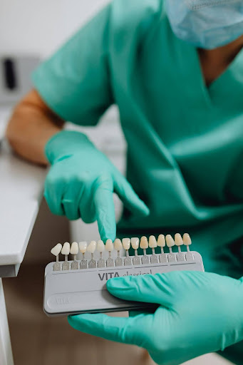 A dentist pointing to a sample on a VITA classical tooth shade guide
