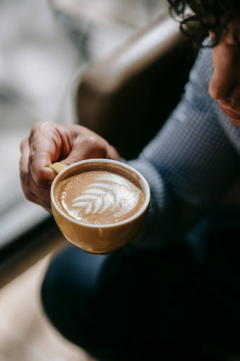 Hand holding coffee cup with latte art