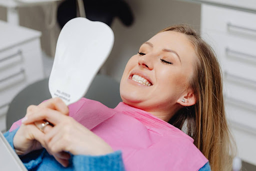 Patient looking at teeth in a mirror at the dentist