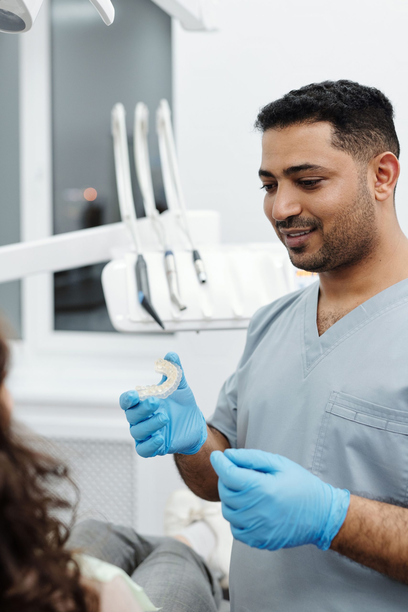 Dentist showing a clear aligner to a patient