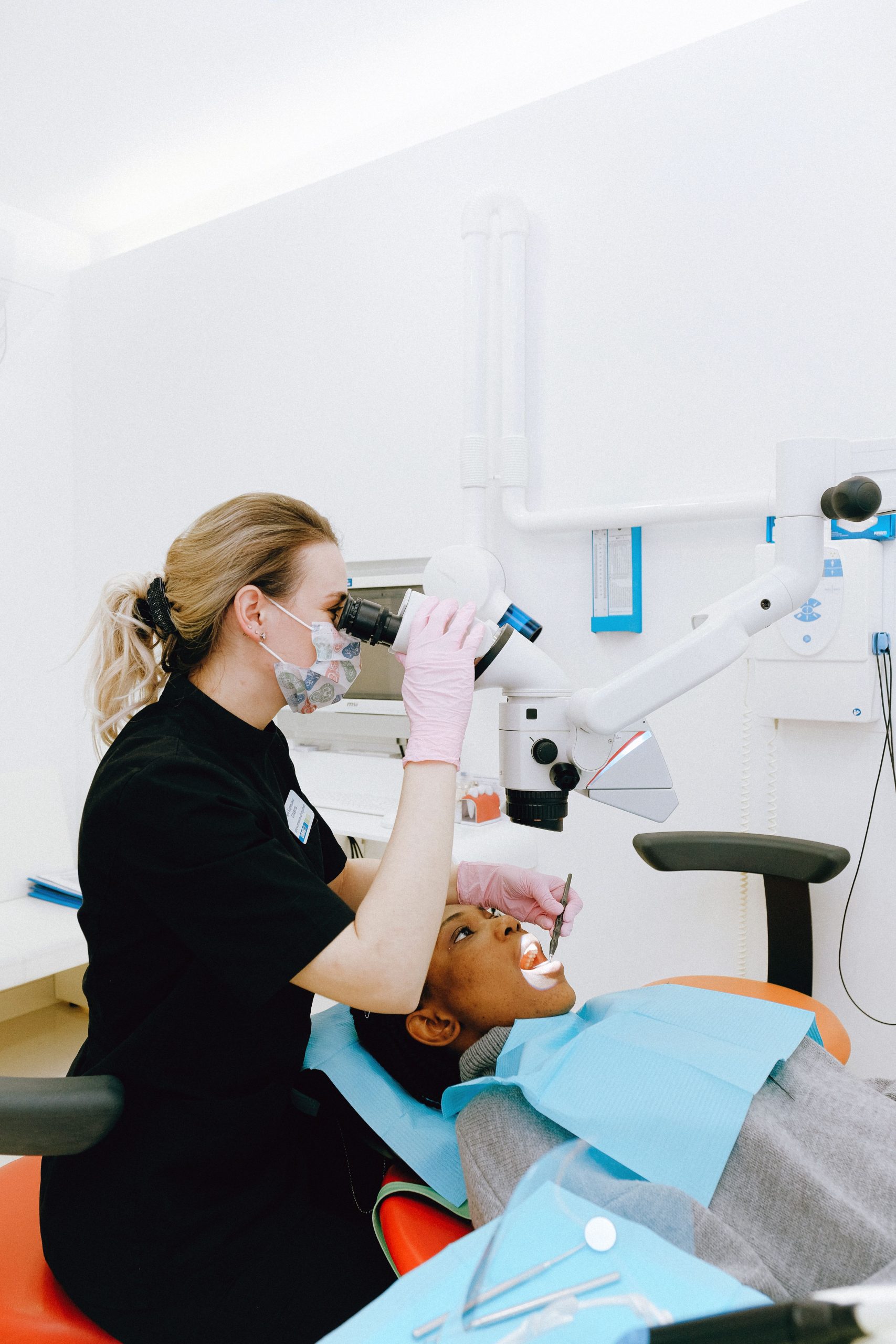 Dentist using a microscope for a root canal treatment in a modern clinic